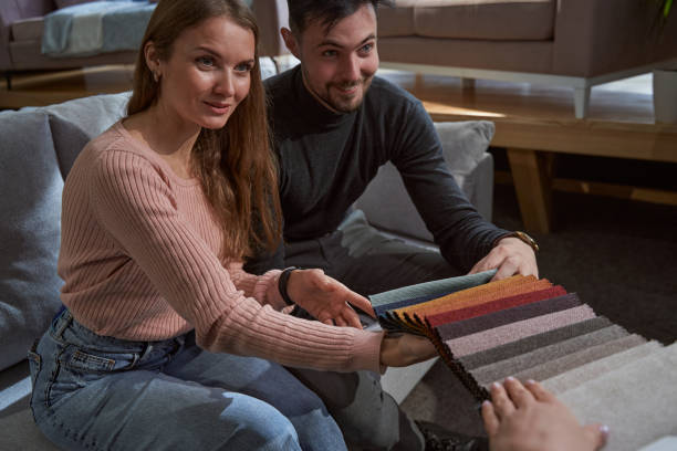 istock Two young buyers choosing sofa upholstery material 1358824497