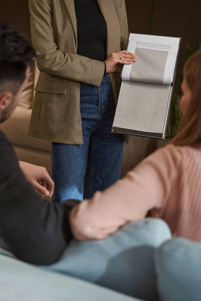 istock Salesperson demonstrating sofa fabric samples to buyers 1358824528