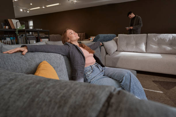 istock Smiling woman customer shopping for right couch 1358824570