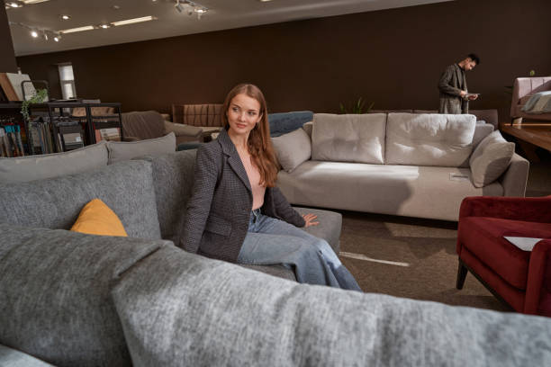 istock Smiling tranquil female shopper choosing new couch 1358824573