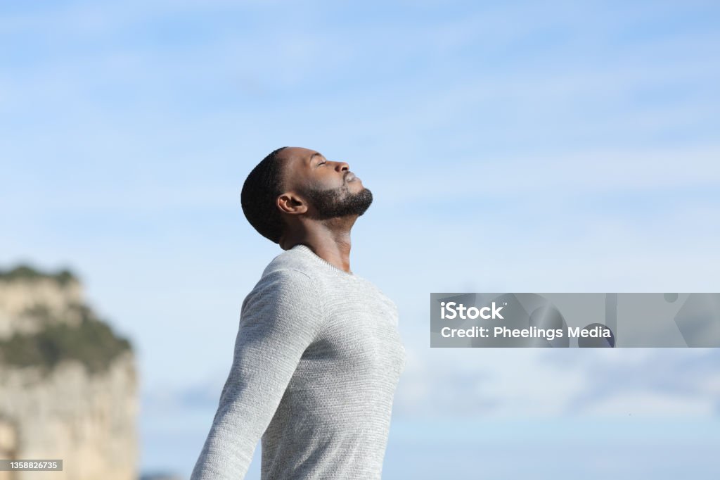 Man with black skin relaxing breathing fresh air outside Breathing Exercise Stock Photo