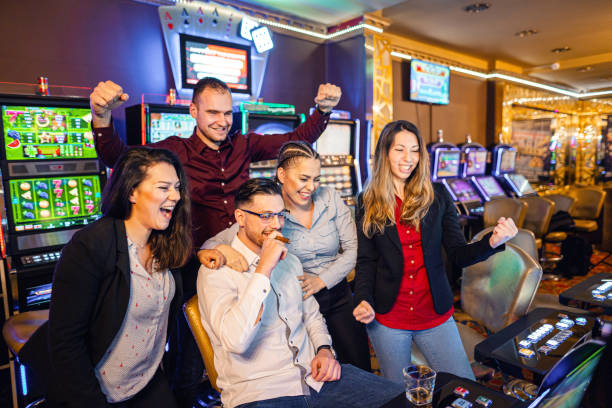 istock Happy group of friends winning while playing on slot machines 1358828809