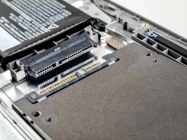 istock Connecting a hard disk in a laptop via the SATA connector, replacing the SSD, installing modern data drives 1358830678