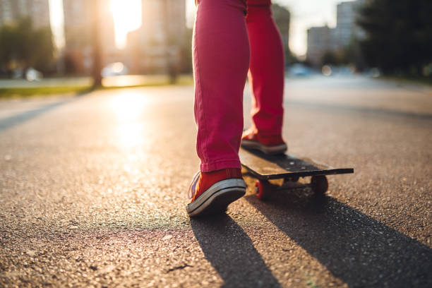 A close-up of a young woman's shoes on a skateboard.