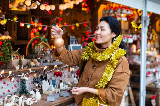 istock Asian female choosing decorations at Christmas fair 1358832329