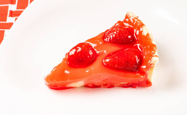istock Strawberry pie slice on a white plate on a red and white tablecloth, selective focus. 1358832546