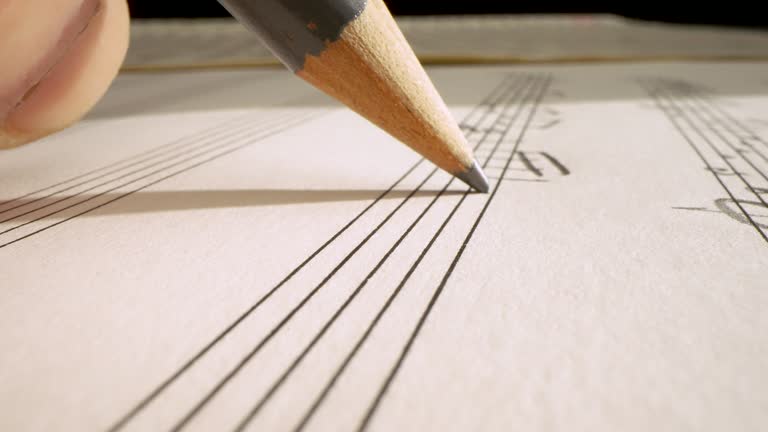 writing on musical score with pencil