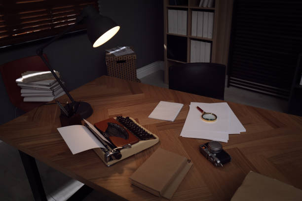 istock Photos, papers and typewriter on desk in office. Detective's workplace 1358833555
