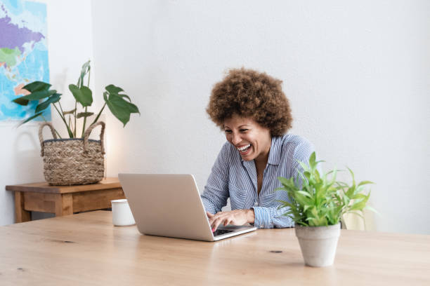 istock Happy african mature woman using laptop computer at home office - Focus in face 1358834022