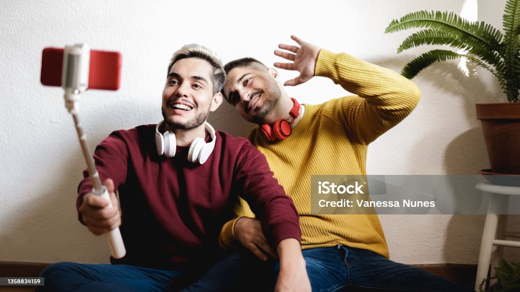 Gay couple streaming online on social media with mobile phone - Lgbt, technology trendy concept - Focus on left man face Live Streaming Stock Photo