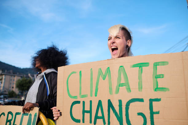 istock Activists shouting and protesting against climate change with banners in the street. 1358834395