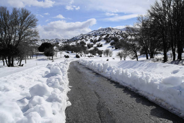 Unique panoramic view of Psiloritis mountains frozen heights. Road on pristine snow, snow covered peaks, hiking paths, and trails at over 2000m altitude. Heraklion, Crete Greece