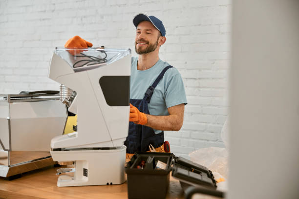 istock Joyful man repairing coffee machine in cafe 1358842539