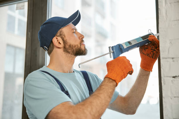 istock Repairman fixing window with silicone adhesive gun 1358842540