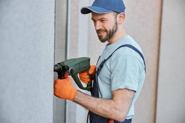 istock Joyful young man drilling wall with hammer drill 1358842770