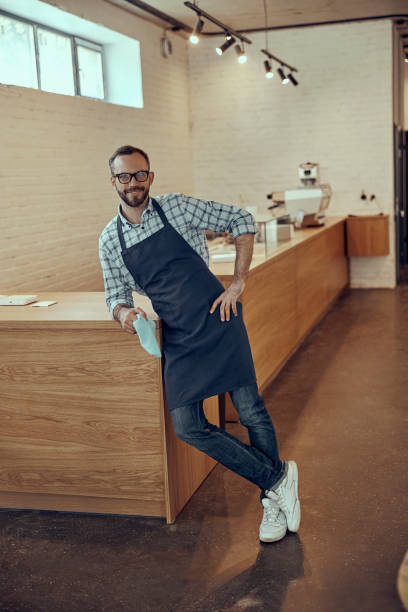 istock Cheerful male bartender leaning on counter in cafe 1358842820