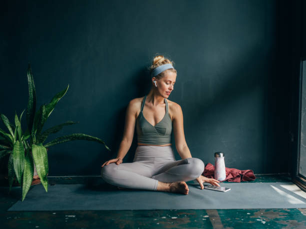 istock Smiling Woman Using Mobile Phone at Yoga Studio 1358843445