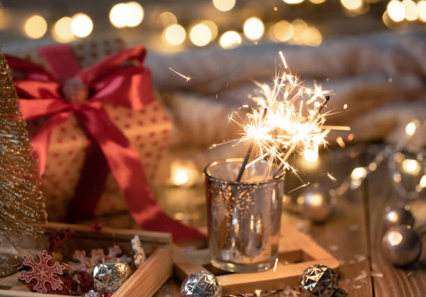 Cozy Christmas background with glowing sparklers and decor details.