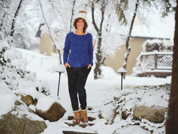A young woman enjoying the freshly falling winter snow.