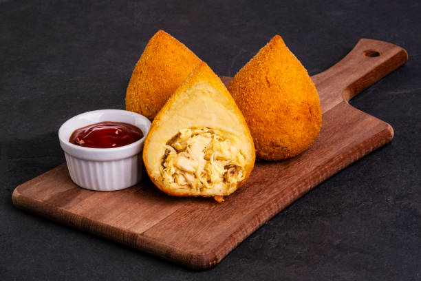 traditional fried coxinha on a wooden board over slate stone traditional fried coxinha on a wooden board over slate stone. coxinha stock pictures, royalty-free photos & images