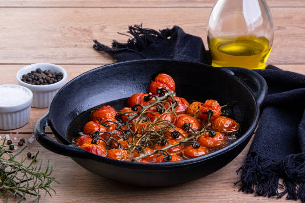 iron casserole with confit tomatoes on wood table