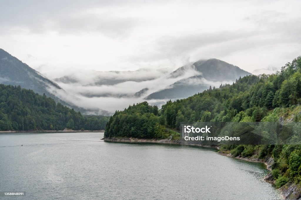 Sylvenstein Reservoir in the Alps of Upper Bavaria Sylvenstein Reservoir in the Alps of Upper Bavaria, Clouds hanging low in the Mountains, Germany Autumn Stock Photo