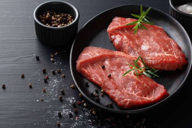 istock Fresh meat with ingredients for cooking on dark table 1358849800