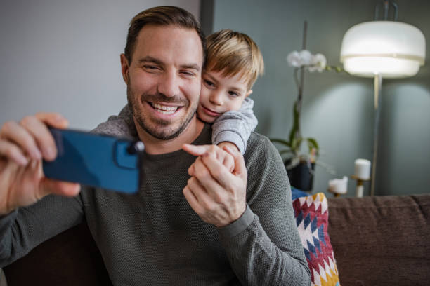 istock Young boy and his father taking a selfie 1358853530