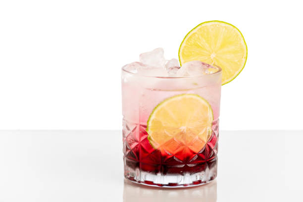 istock glass with red drink decorated with orange and cucumber on white background. 1358854538