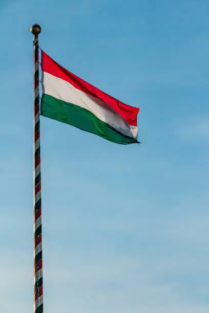 Hungary, Hungarian national flag waving on blue sky background