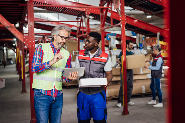 istock Mature manager at the warehouse organizing duties for his young worker 1358859738