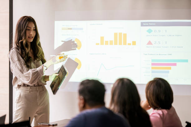 istock Asian lady presenting to colleagues in conference room 1358862042