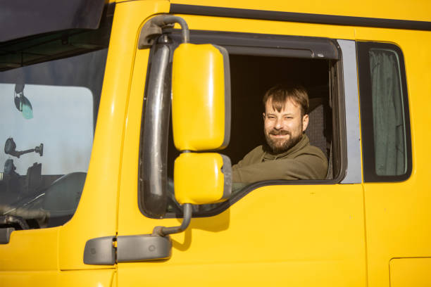 istock Truck driver sitting in cabin and looking at camera 1358862283