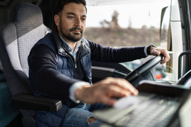 istock Truck driver typing destination on tablet while sitting in cabin 1358862871