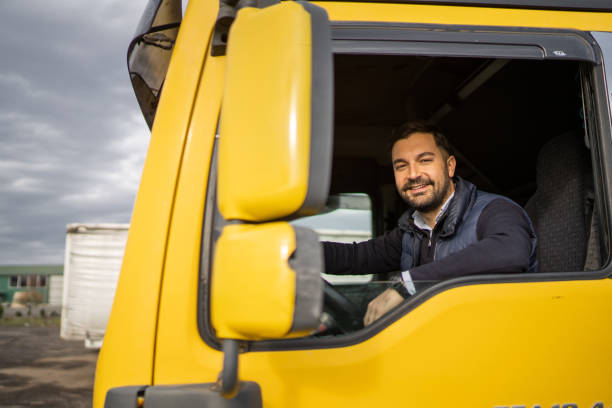 istock Truck driver sitting in cabin and looking at camera 1358863708