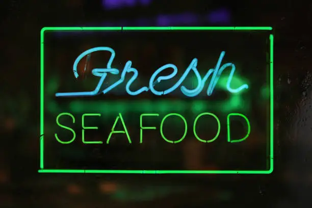 Photo of Neon Fresh Seafood Sign in Rainy Window