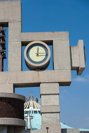 A low angle of a Roman numeral Clock Tower in the city of London, England on a cloudy summer day