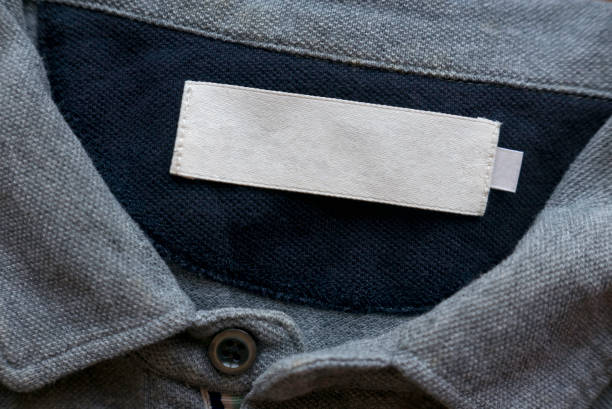 istock Blank white laundry care clothes label on grey fabric texture background. 1358866615