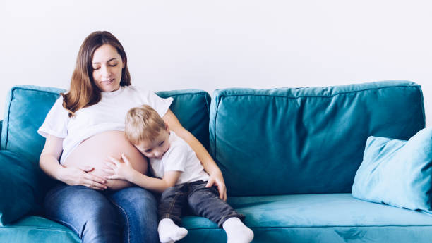 istock Cute small boy talking with his pregnant mother 1358867020