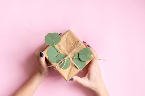 istock Gift box wrapped in brown paper decorated with eucalyptus branch 1358867064