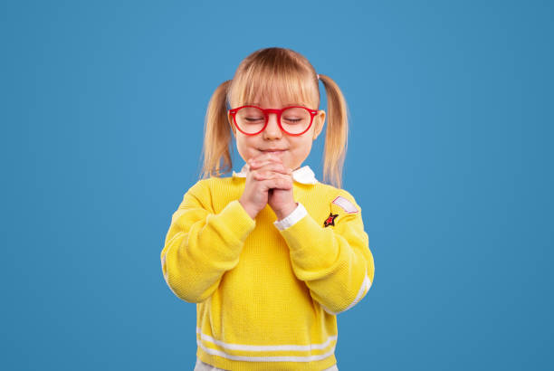 niña orando con los ojos cerrados - praying girl fotografías e imágenes de stock