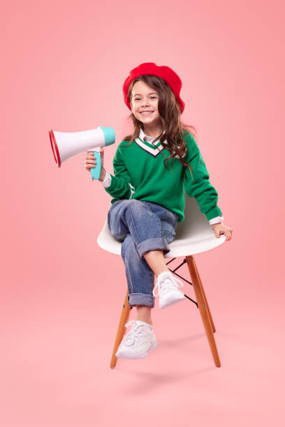 Little leader with loudspeaker sitting on chair