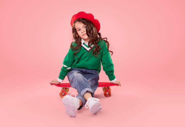 istock Trendy child sitting on skateboard 1358868194