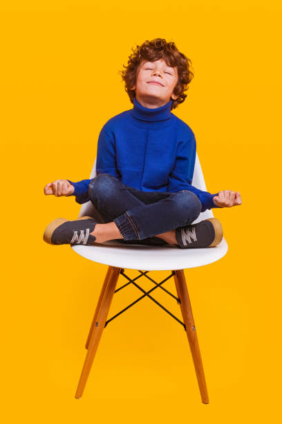 istock Happy boy meditating on chair 1358868218