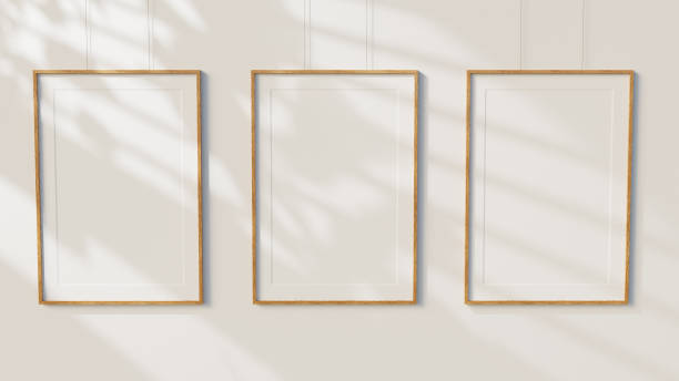 istock Three Minimal blank wooden picture frames on white wall background 1358868786