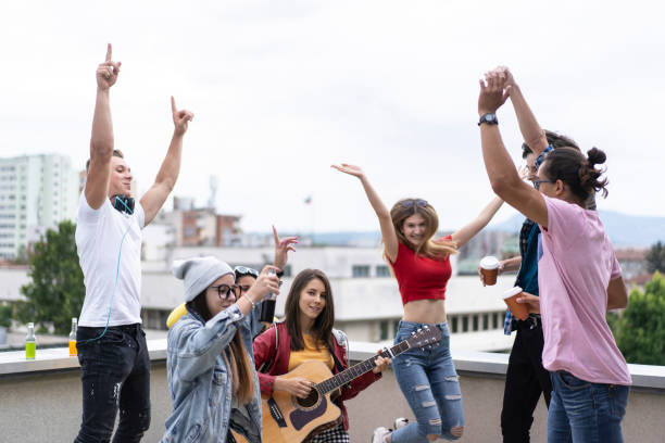 istock Friends having fun, singing songs on a rooftop 1358869040