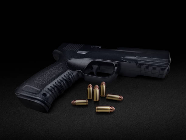 istock Gun with ammunition on black background 1358881409