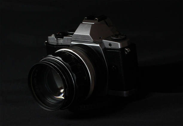 istock Vintage black camara with lens on black background 1358881432