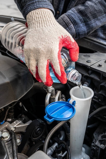 Automobile Maintenance. Filling the Windshield Washer Fluid on a Car. stock photo