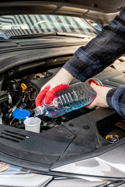 istock Automobile Maintenance. Filling the Windshield Washer Fluid on a Car. 1358881475
